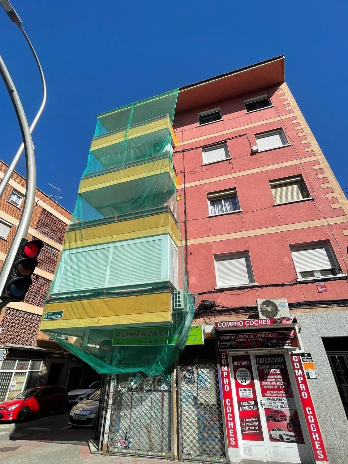 Fachada de comunidad en pleno proceso de rehabilitación, con la red de protección montada